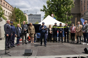 Na scenie zaproszeni goście, policjant mówi przez mikrofon.