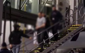 policjanci prowadzą zatrzymanego.