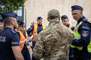Policjanci z centrum dowodzenia rozmawiają.