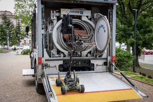 Robot na samochodzie specjalistycznym umieszcza ładunek w specjalnym pomieszczeniu.