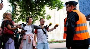 Policjant udziela wywiadu do mediów, dziennikarze trzymają mikrofony.