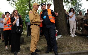Policjant rozmawia z strażakiem.
