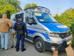 Funkcjonariusz Straży Granicznej i policjant prowadzą zatrzymanego.