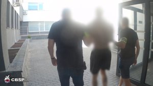 Policjanci prowadzą zatrzymanego.
