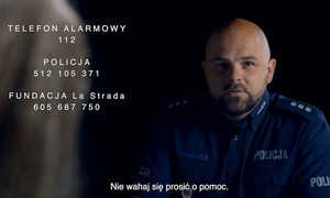 Policjant w tle i napisy z numerami pomocowymi.