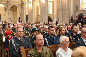 Msza święta policjanci i uczestnicy siedzą w ławkach.