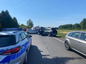 Samochód rozbity na drodze, radiówóz policyjny.