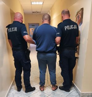 Na zdjęciu zatrzymany z policjantami.