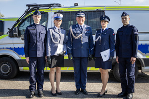Policjantki i policjanci przy radiowozie.