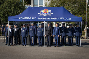 Kadra kierownicza i zaproszeni goście stoją pod namiotem.