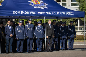 Kadra kierownicza i zaproszeni goście stoją pod namiotem.
