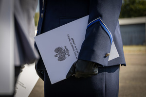 Ręka policjanta, policjant trzyma akt mianowania.