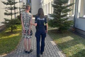 Policjantka prowadzi zatrzymanego.