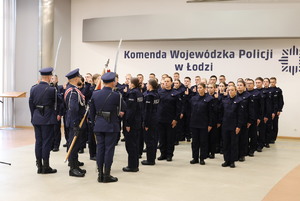 Młodzi policjanci przed sztandarem.