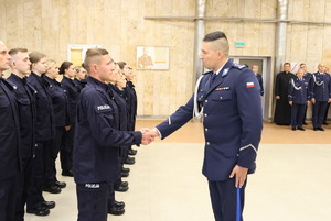 Komendant gratuluje jednemu z policjantów.