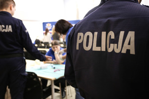 Dwóch policjantów stojących tyłem.