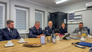 Delegacja policji niemieckiej siedzi za stołem.
