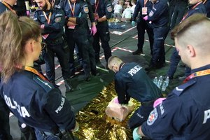 Policjant wykonujący resuscytację krążeniowo-oddechową na fantomie.