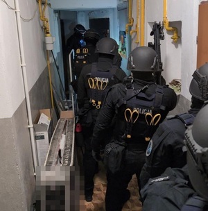 Kontrterroryści stoją jeden za drugim w pomieszczeniu.