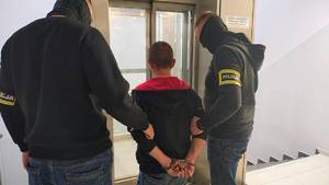 Policjanci prowadzą zatrzymanego.