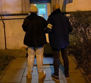 Policjant z zatrzymanym mężczyzną.