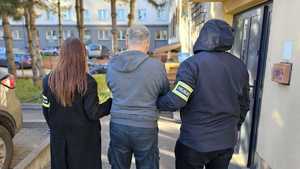 Policjanci prowadzą zatrzymanego.