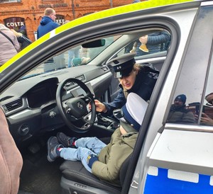 Policjantka siedzi w samochodzie z dzieckiem.