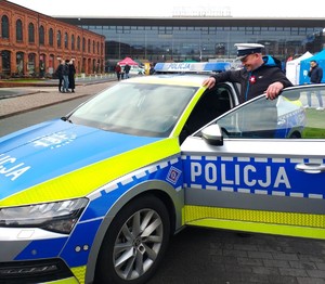 Radiowóz policyjny obok policjant.