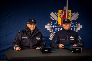 Komendant z przedstawicielem KGP podpisują pod namiotem porozumienie.