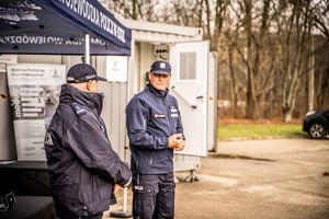 Komendant z przedstawicielem z KGP stoja przy namiocie.