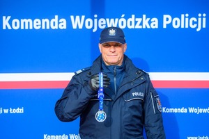 Komendant trzyma w ręku medal.