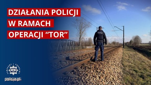 policjant stojący przy torach kolejowych.