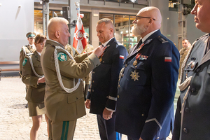 Komendant wojewódzki Policji w Łodzi ma wręczany medal.
