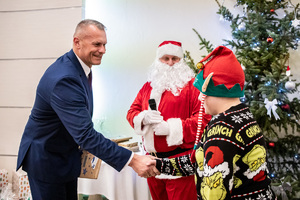 Mikołaj i Komendant Wojewódzki Policji w łodzi podaje rękę chłopczykowi.