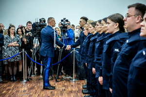 Ślubujący policjanci. Komendant wita się z policjantami.