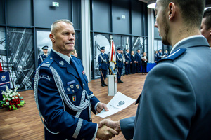 Komendant wręcza akt mianowania policjantowi.