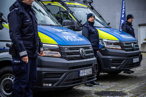 Policjanci obok nowych radiowozów.