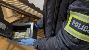 Funkcjonariusz zabezpiecza pieniądze.