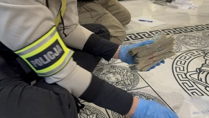 Funkcjonariusz zabezpiecza pieniądze.