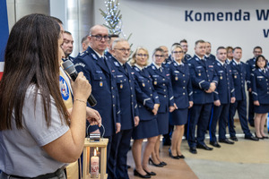 Przemawia harcerka, obok policjanci w mundurach.