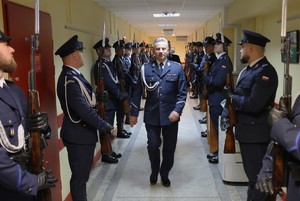 Komendant w drodze na uroczystość wśród policjantów.