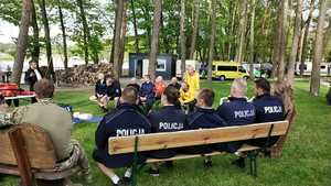 Szkolenie policjantów, policjanci siedzą na ławce.