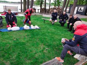 Na trawie medycy pokazują pierwszą pomoc.