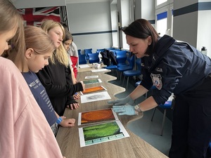 Policjantka pokazuje odciski palców dzieciom.