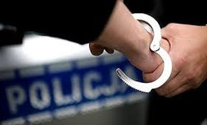 Policjant zakłada kajdanki.