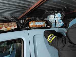 Policjant zabezpiecza nielegalny tytoń.