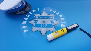 Czapka policyjna, alkomat napis Pomagamy i Chronimy Policja 112.