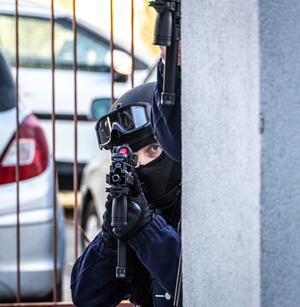 Policjant mierzy z broni.