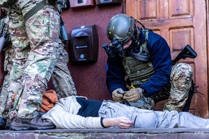 Policjant pomaga poszkodowanemu.