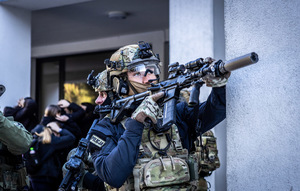 Policjant z długą bronią.